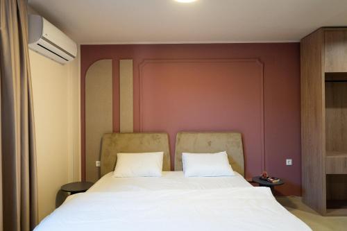 a bed in a room with a red wall at Dremka Guesthouse Peshtani in Ohrid