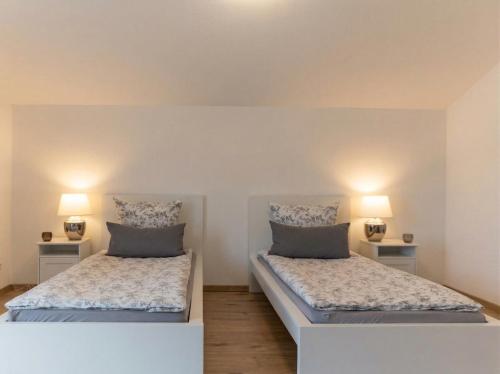 two beds in a room with two lamps at Ferienwohnung Elena in Tettnang