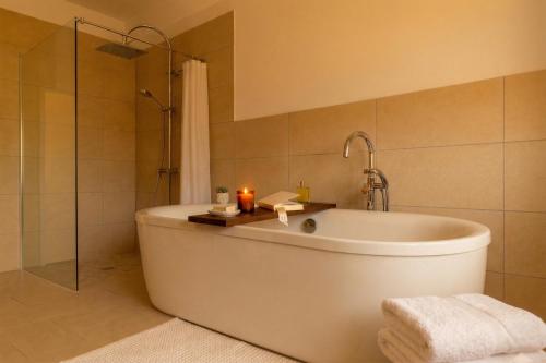 a bathroom with a tub and a shower with candles at Ferienwohnung Elena in Tettnang