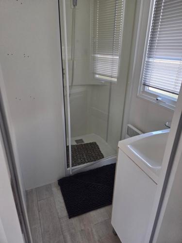 a small bathroom with a shower and a sink at FMLODGE la cabane du soleil au sable du midi in Sérignan