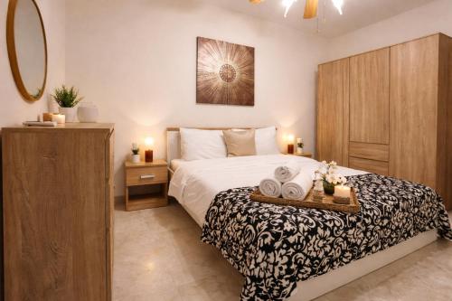 a bedroom with a bed with a tray of towels at Seafront Maisonette Ocean Views & Terrace in Mellieħa