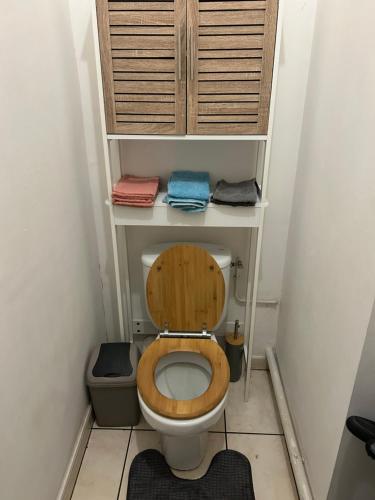 a small bathroom with a toilet with a wooden seat at LE MERYCE appt in Saint-Denis
