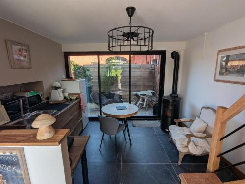 a kitchen and living room with a table and chairs at Le Pigeonnier in Rosult