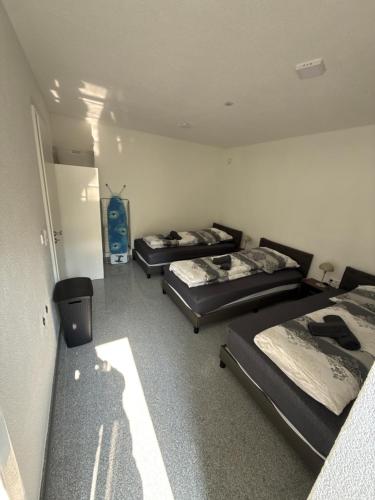 a room with three beds in it with a room with a refrigerator at Team at Home Senden in Senden