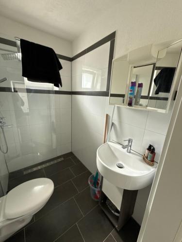 a white bathroom with a sink and a toilet at Team at Home Senden in Senden