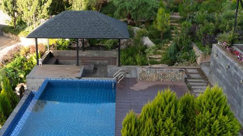 an overhead view of a swimming pool with an umbrella at Zenora Hillside Garden in Da Lat
