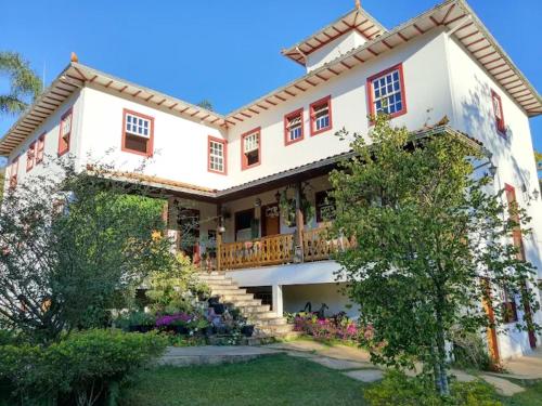 a large white house with a balcony and a yard at Pousada da Serrinha in Mariana