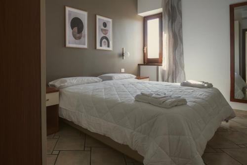 a bedroom with a large bed with towels on it at Hera Home B&B in Serra Pedace