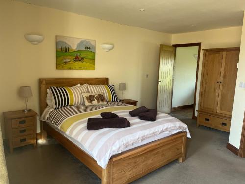 a bedroom with a large bed with two towels on it at Weatherhead Farm in Buckingham