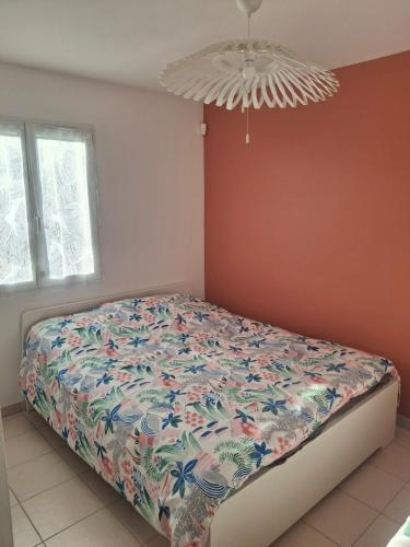 a bedroom with a bed with a floral bedspread at La Motte in La Motte