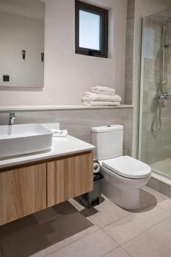 a bathroom with a toilet and a sink and a shower at Verdant Comfort Apartment in Moka