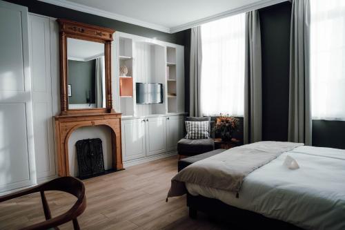 a bedroom with a bed and a mirror and a fireplace at Villa Dolce in Silly