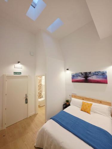 a bedroom with a bed and a painting on the wall at Bilbao ROOMS & KITCHEN Zabalburu in Bilbao