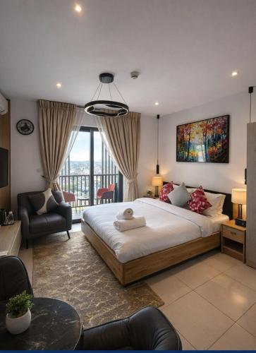 a bedroom with a large bed and a living room at LoxwoodStudio by UniqueView in Accra
