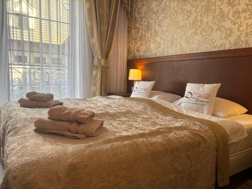 a bedroom with a bed with towels on it at Dwór Kresowy in Radymno