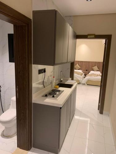 a kitchen with a sink and a stove top oven at منازل الثقة in An Nikāshah