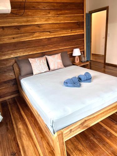 un lit avec des serviettes bleues dessus dans une chambre dans l'établissement Blue Marlin, à Bocas del Toro