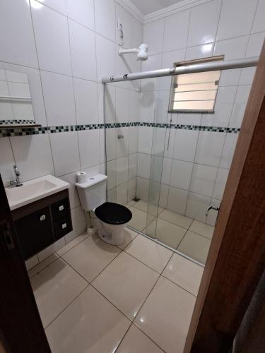 a white bathroom with a toilet and a shower at Recanto Campo Belo in Monte Sião