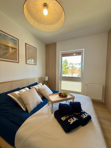 a bedroom with a large bed with a table on it at Apartament Boho Let's Sea Gąski in Gąski
