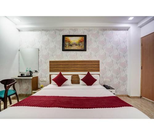 a bedroom with a large white bed with red pillows at Istay By A1Rooms in Jāmb