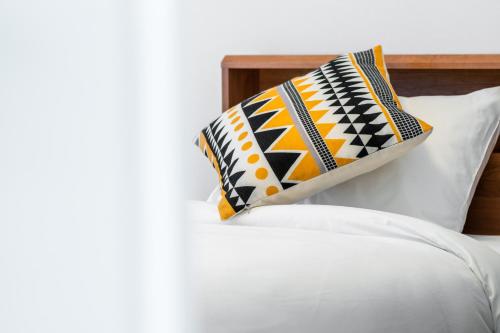a pillow sitting on top of a white bed at Nomad Stay Chitose in Chitose