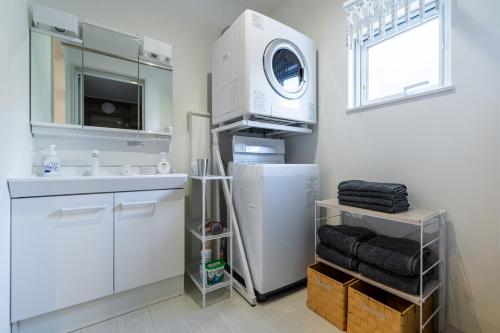 a kitchen with a white refrigerator and a microwave at Nomad Stay Chitose in Chitose