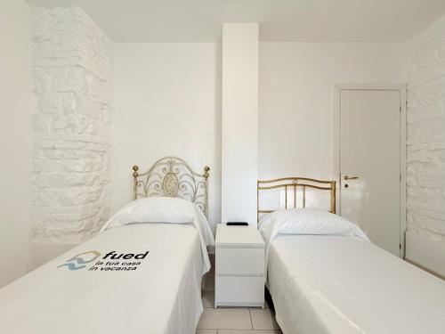 two beds sitting next to each other in a bedroom at CasaMare - Numana, comodo trilocale in centro in Numana