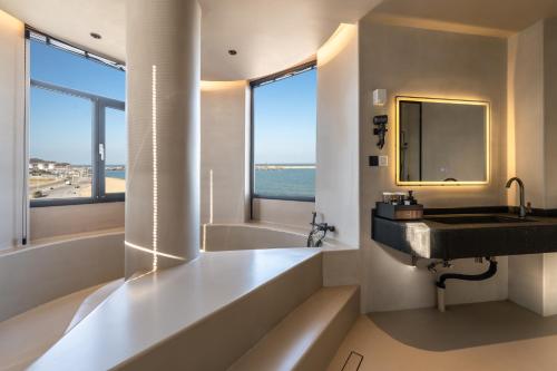 a bathroom with a sink and a tub and a mirror at Bay Four Seasons Castle Hotel in Weihai