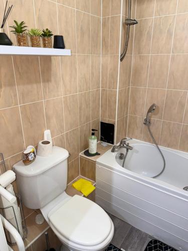 a bathroom with a toilet and a bath tub at One bedroom Flat in Birmingham City Centre with free underground parking in Birmingham