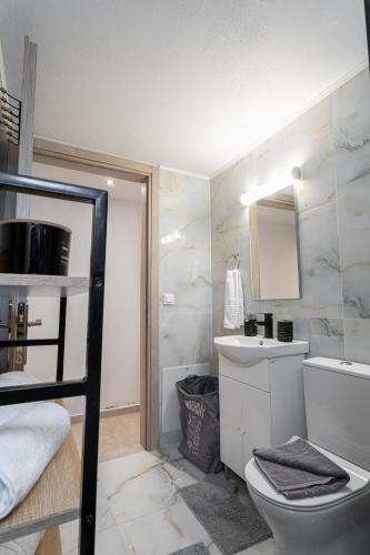 a bathroom with a toilet and a sink at Eros Elysium Retreat Villas in Kalavárda