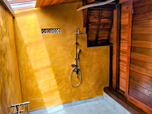 a bathroom with a shower in a wall at Pondok Kayu Canggu in Dalung