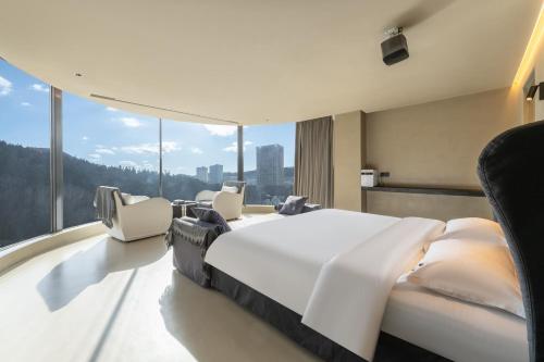 a bedroom with a large white bed and chairs at Bay Four Seasons Castle Hotel in Weihai