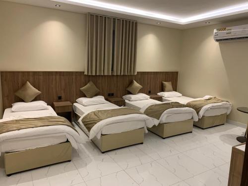 a group of four beds in a room at منازل الثقة in An Nikāshah