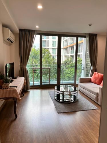 a living room with a couch and a table at 1Bedroom+Sofa bed, Luxury Condo@Nimmana in Chiang Mai
