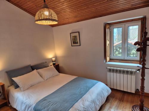 a bedroom with a bed and a window at Casinha do Pátio in Nogueira do Cravo