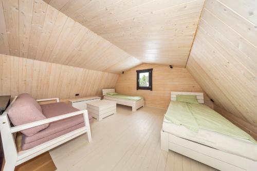 a room with two beds in a wooden house at Voose Päikesekodu seminari- ja puhkekeskus in Vose