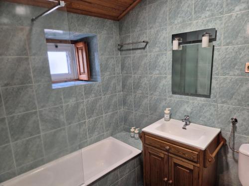 a bathroom with a sink and a bath tub at Casinha do Pátio in Nogueira do Cravo