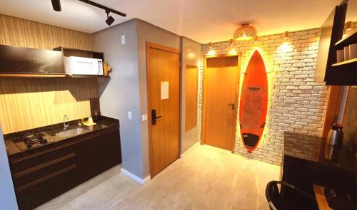 a kitchen with a surfboard hanging on a brick wall at Salt Beach Atalaia Residence Inn in Salinópolis