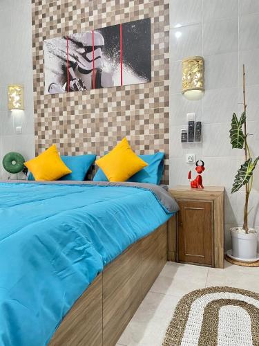a bedroom with a bed with blue and yellow pillows at 1 BR Private Studio Apartment with Kitchen in Kerobokan