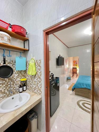 a bathroom with a sink and a kitchen with a bed at 1 BR Private Studio Apartment with Kitchen in Kerobokan