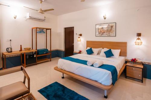 a bedroom with a large bed and a chair at Moustache Daman in Daman