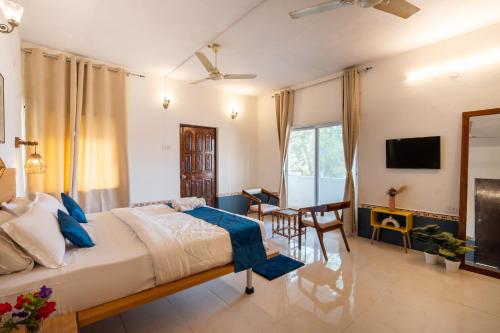 a bedroom with a bed and a table and chairs at Moustache Daman in Daman