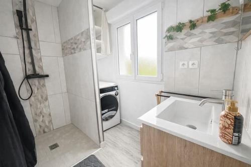 a white kitchen with a sink and a stove at Au rucher in Fressin