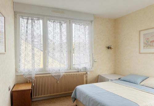 a bedroom with a bed and a large window at Hostellerie de la juhel in Villaines-la-Juhel