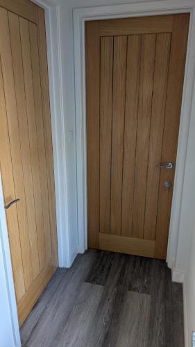 an empty room with a door and wooden floors at Chyvena in Ruan Minor