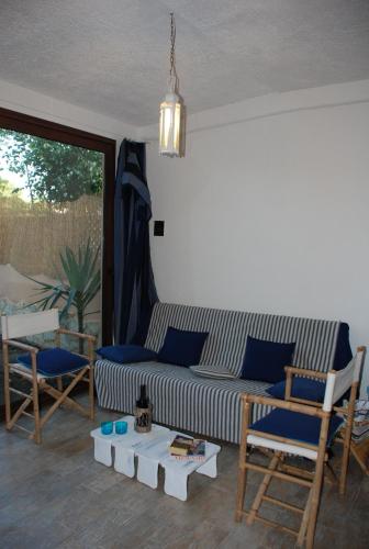 a living room with a couch and chairs and a table at Villa stella di mare in Capitana