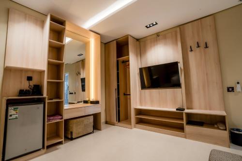 a living room with wooden cabinets and a television at Aurion AsSalaam Hotel Apartment in Medina