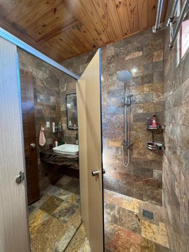 a bathroom with a shower with a sink and a tub at R Chai in Countach Da