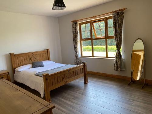 a bedroom with a bed and a large window at Hill Farm in Dunmore