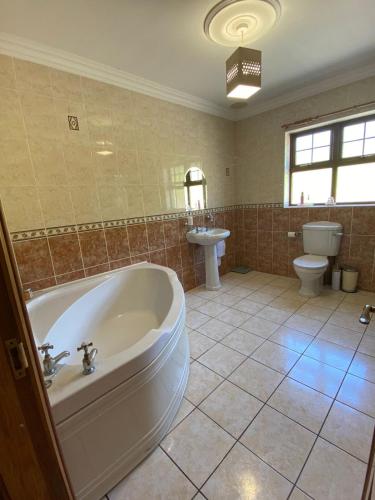 a bathroom with a tub and a toilet and a sink at Hill Farm in Dunmore